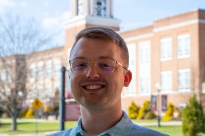 A photo of Bryce Mutterback standing in front of the Concord University Bell Tower.