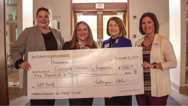 A photo of Caitlin Thompson, Kayla Karr, Kendra Boggess, and Sarah Turner holding a giant check worth $5000 from the Enterprise Holdings Foundation to the Concord University Gap Fund.