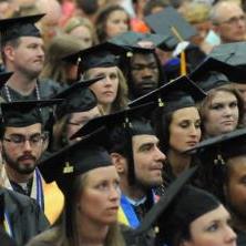 A group of Concord University graduates sitting in their caps and gowns at the commencement ceremony