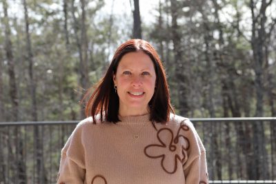 A photo of Sonya Baldwin against a sunny wooded backdrop.