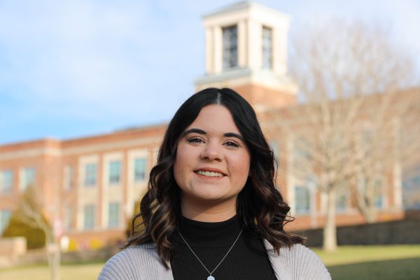 A photo of Madeline Hawkins with Concord's bell tower in the backdrop.