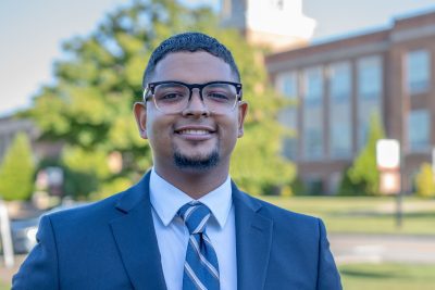 A photo of Joanthony Hernandez with the Concord campus greenery in the background.